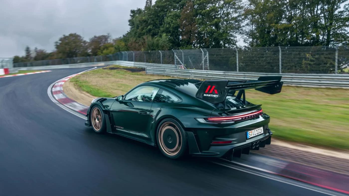 Porsche on track at night with FLUXX neon sign